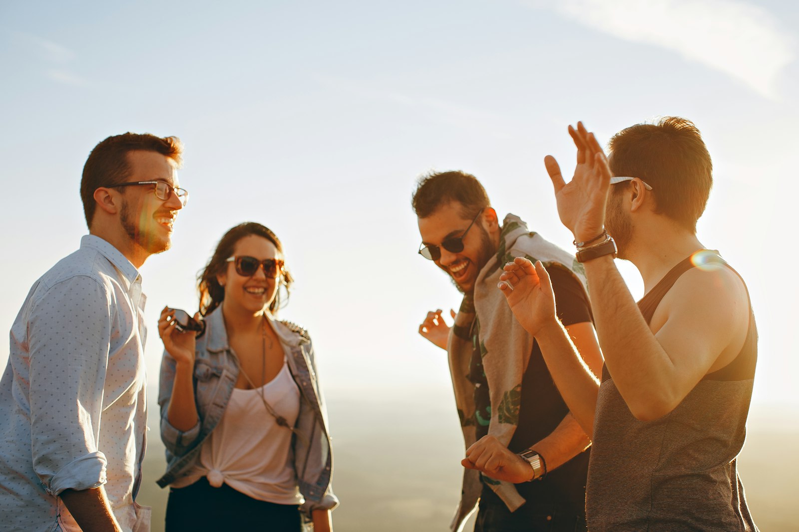 Four people laughing together outdoors